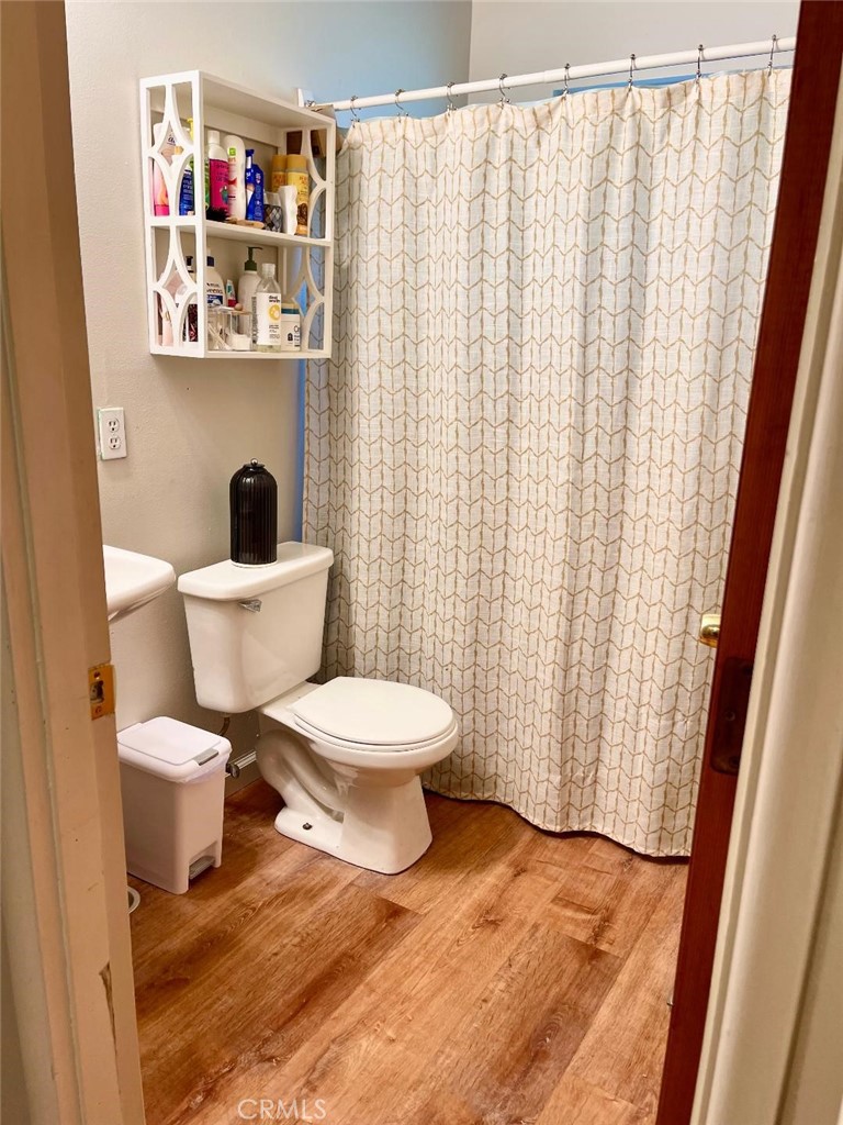 1640 Celeste Court Merced, CA 95341 - Photo 11 of 19 a white toilet sitting next to a bathroom sink and a shower curtain
