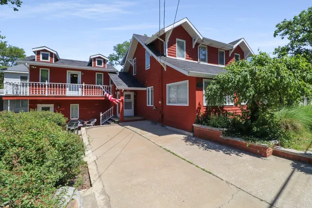 a front view of a house with a yard and trees