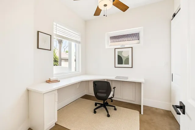 a view of a workspace with furniture and a window