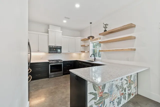 a kitchen with stainless steel appliances granite countertop a sink stove and refrigerator