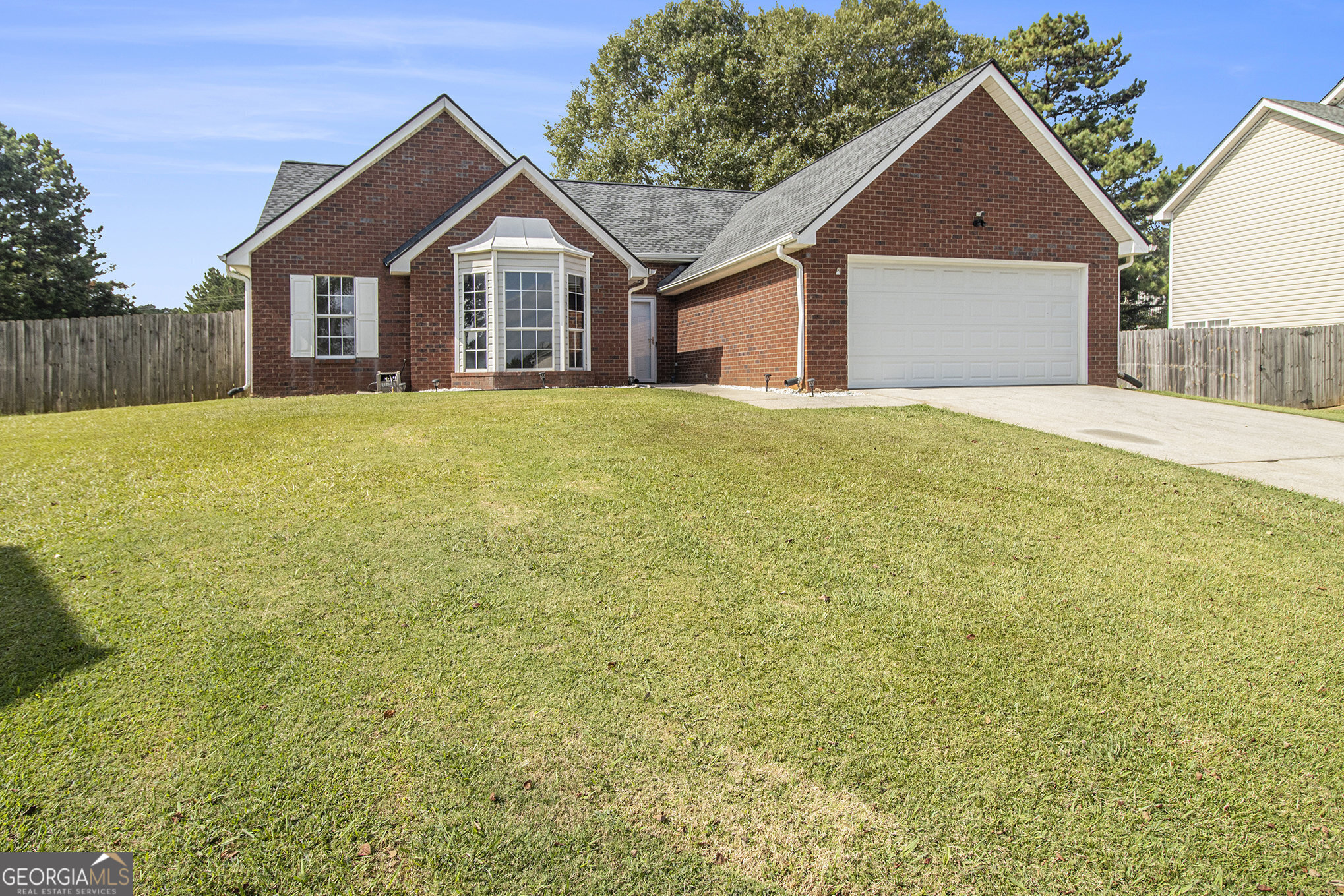 8195 Rhodes Way Riverdale, GA 30274 - Photo 1 of 1 a view of a house with a yard and garage