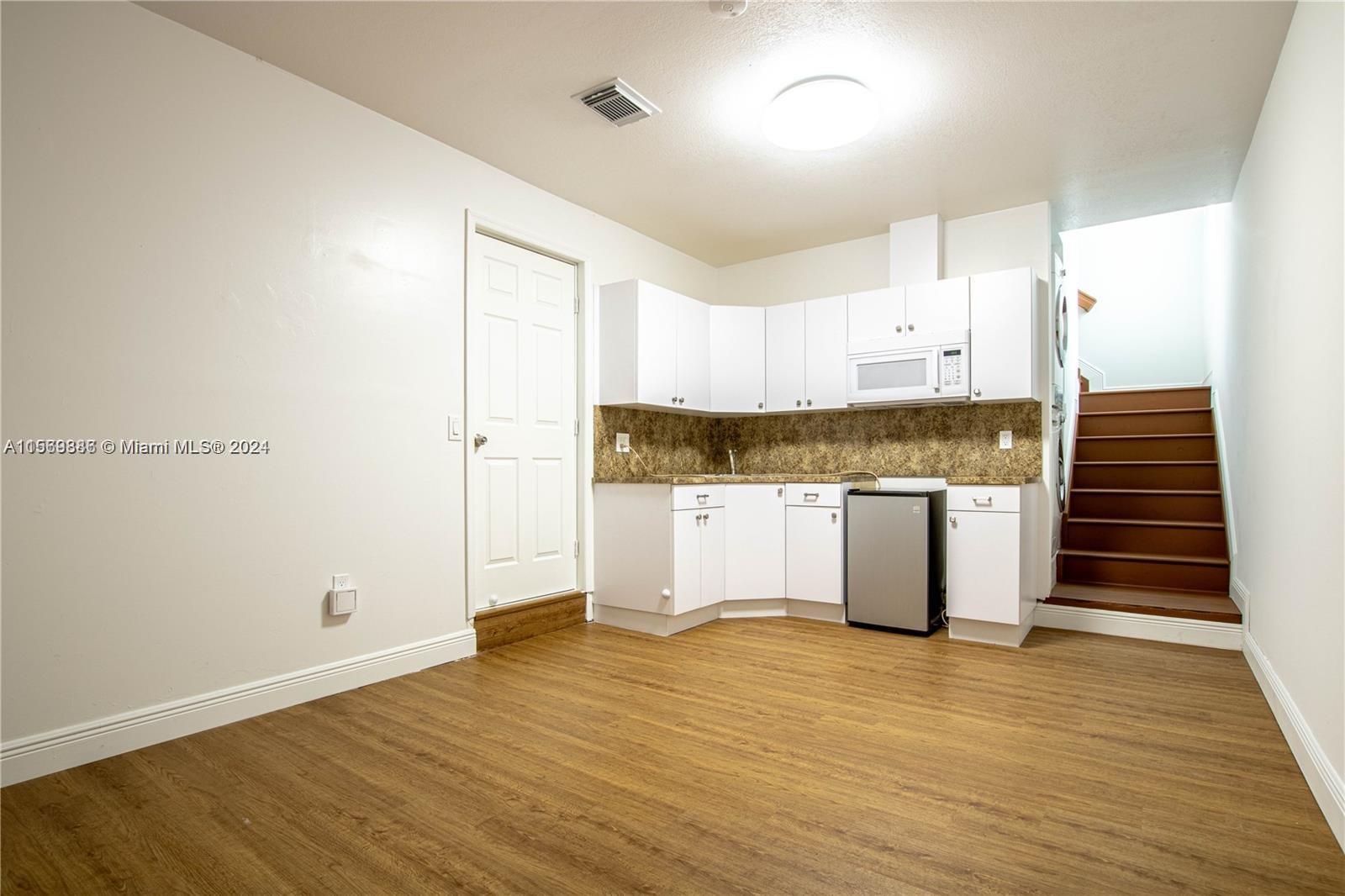 16227 Southwest 139th Court, Unit 2 Miami, FL 33177 - Photo 1 of 9 a view of a kitchen with wooden floor and electronic appliances