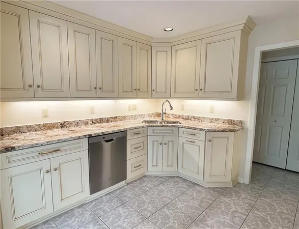 a kitchen with granite countertop white cabinets and stainless steel appliances