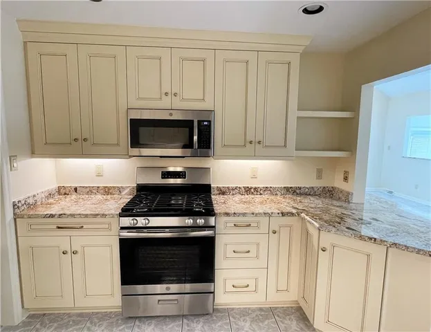 a kitchen with stainless steel appliances granite countertop a sink stove and refrigerator