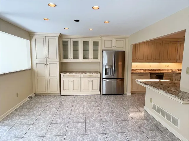 a kitchen with stainless steel appliances granite countertop a refrigerator and a stove top oven