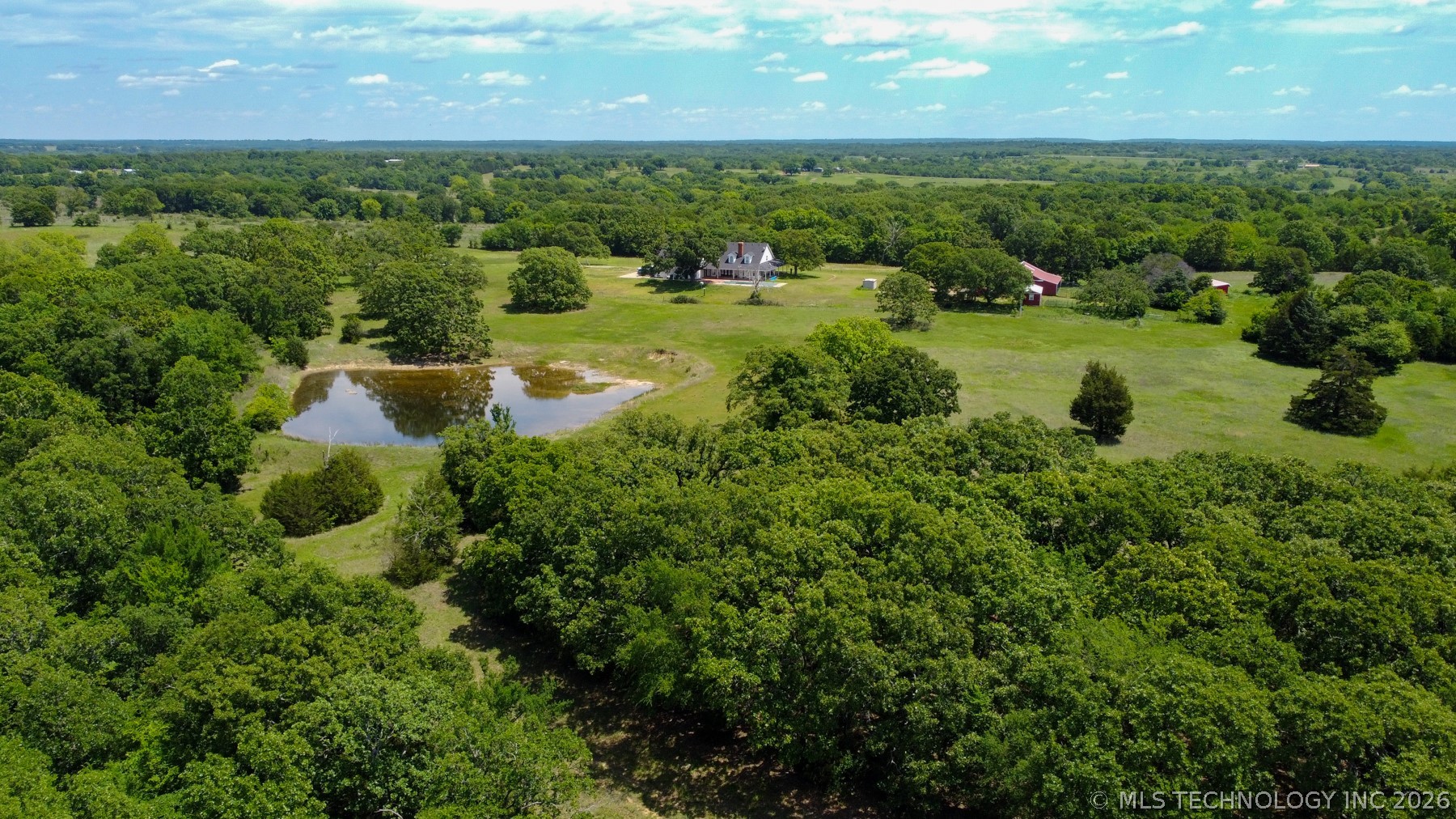 13248 North 3540th Road Maud, OK 74854 - Photo 20 of 98 Expansive rural property featuring a large pond, mature trees, and open green spaces
