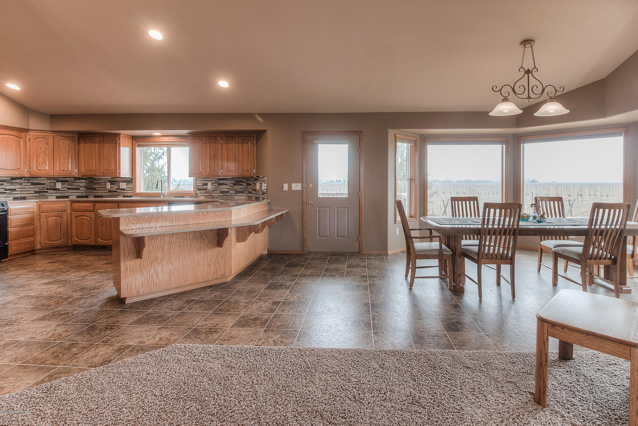 630 Belma Road Grandview, WA 98930 - Photo 14 of 71 a view of a dining room with furniture a chandelier and wooden floor