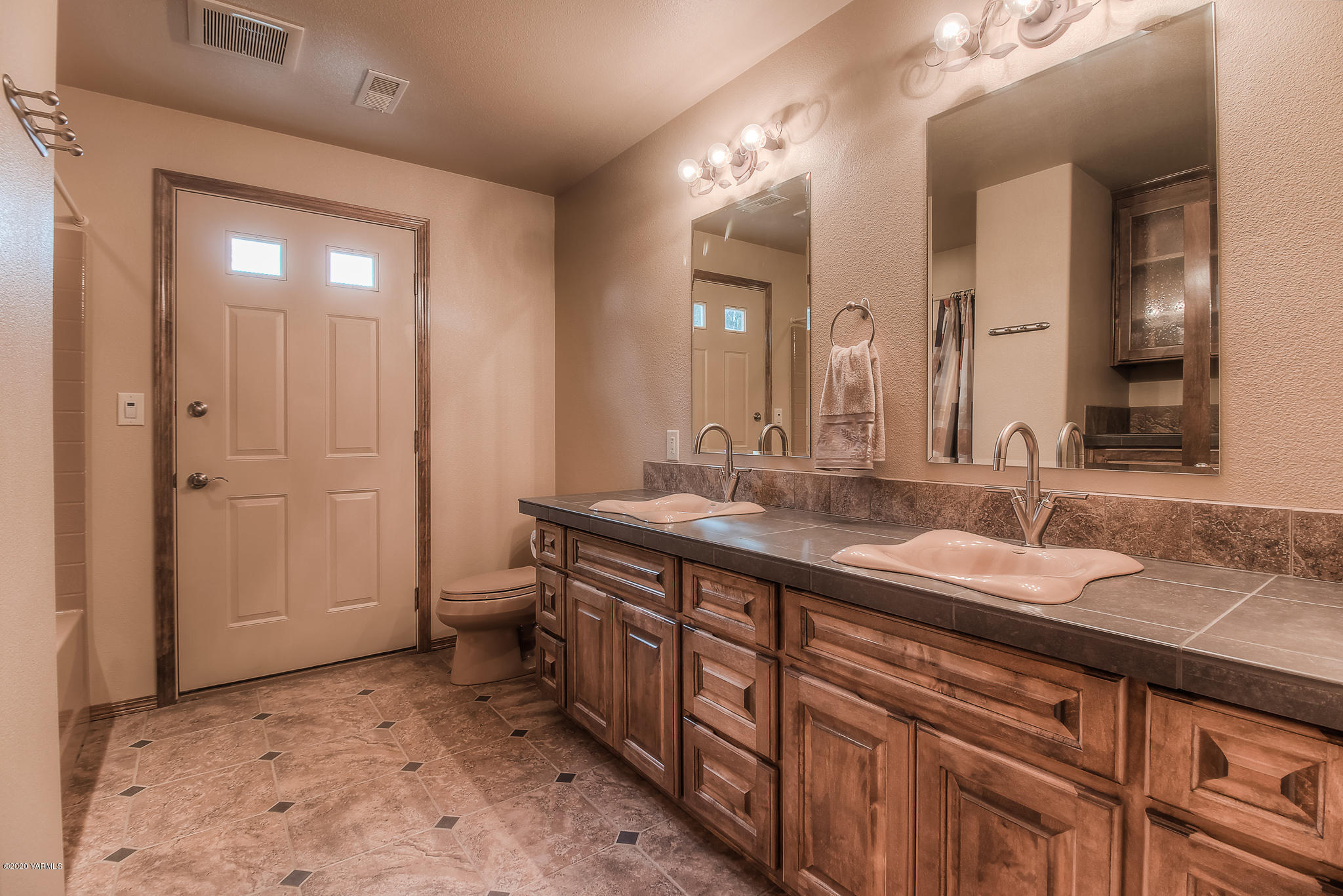 630 Belma Road Grandview, WA 98930 - Photo 35 of 71 a spacious bathroom with a granite countertop sink and a mirror
