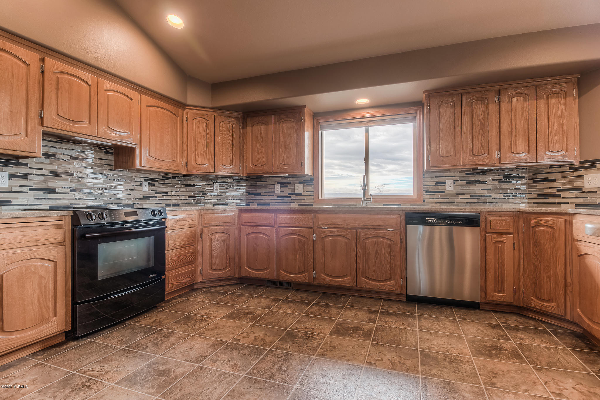 630 Belma Road Grandview, WA 98930 - Photo 5 of 71 a kitchen with kitchen island granite countertop a stove sink and cabinets
