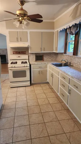 a kitchen with granite countertop a stove a sink and a refrigerator