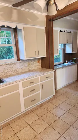 a kitchen with granite countertop white cabinets and white appliances