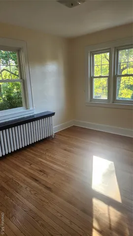 a view of a room with wooden floor and windows