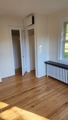 a view of a room with wooden floor and window