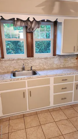 a kitchen with granite countertop a sink and a stove top oven