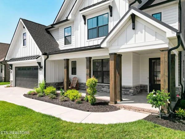 a front view of a house with a garden and plants