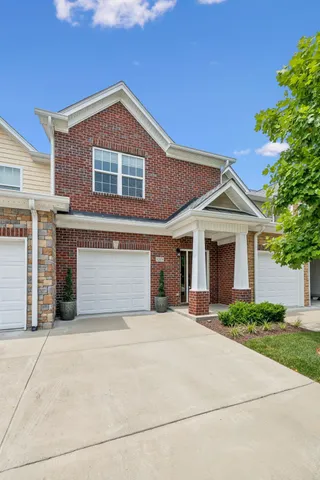 a front view of a house with yard and trees