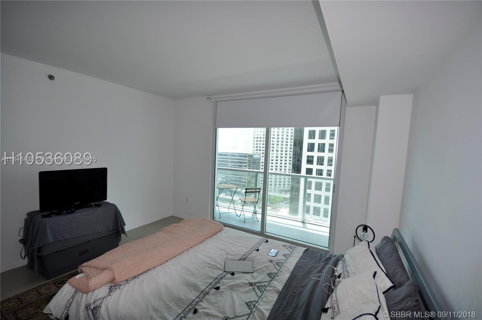 500 Brickell Avenue, Unit 2204 Miami, FL 33131 - Photo 12 of 19 a bedroom with a bed tv and a window