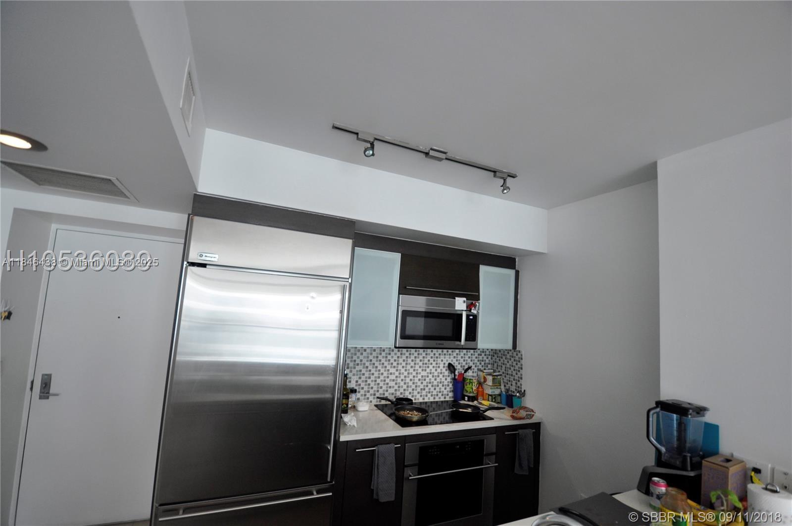 500 Brickell Avenue, Unit 2204 Miami, FL 33131 - Photo 13 of 19 a kitchen with a refrigerator and a stove top oven