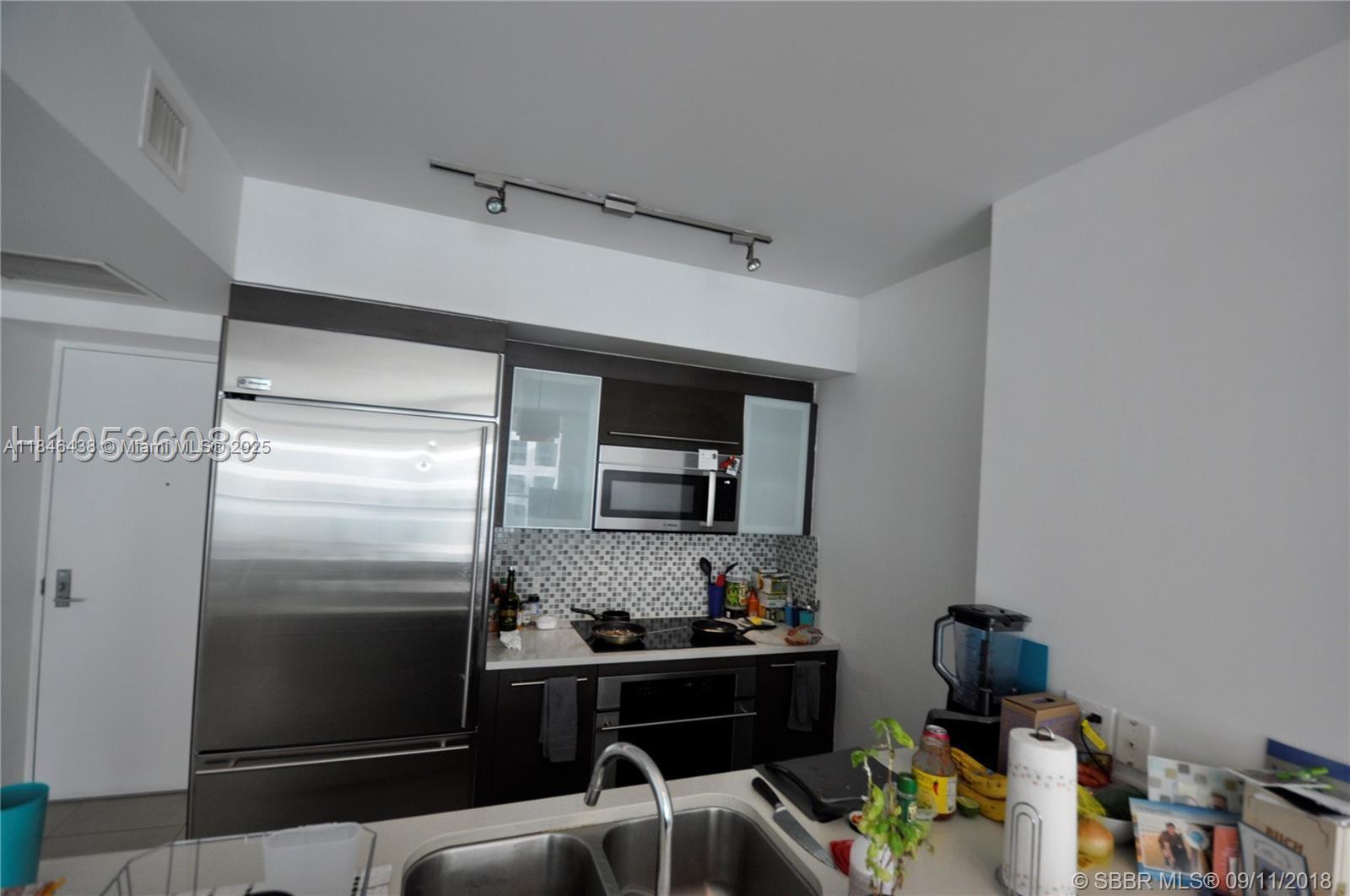 500 Brickell Avenue, Unit 2204 Miami, FL 33131 - Photo 14 of 19 a kitchen with a sink appliances and cabinets