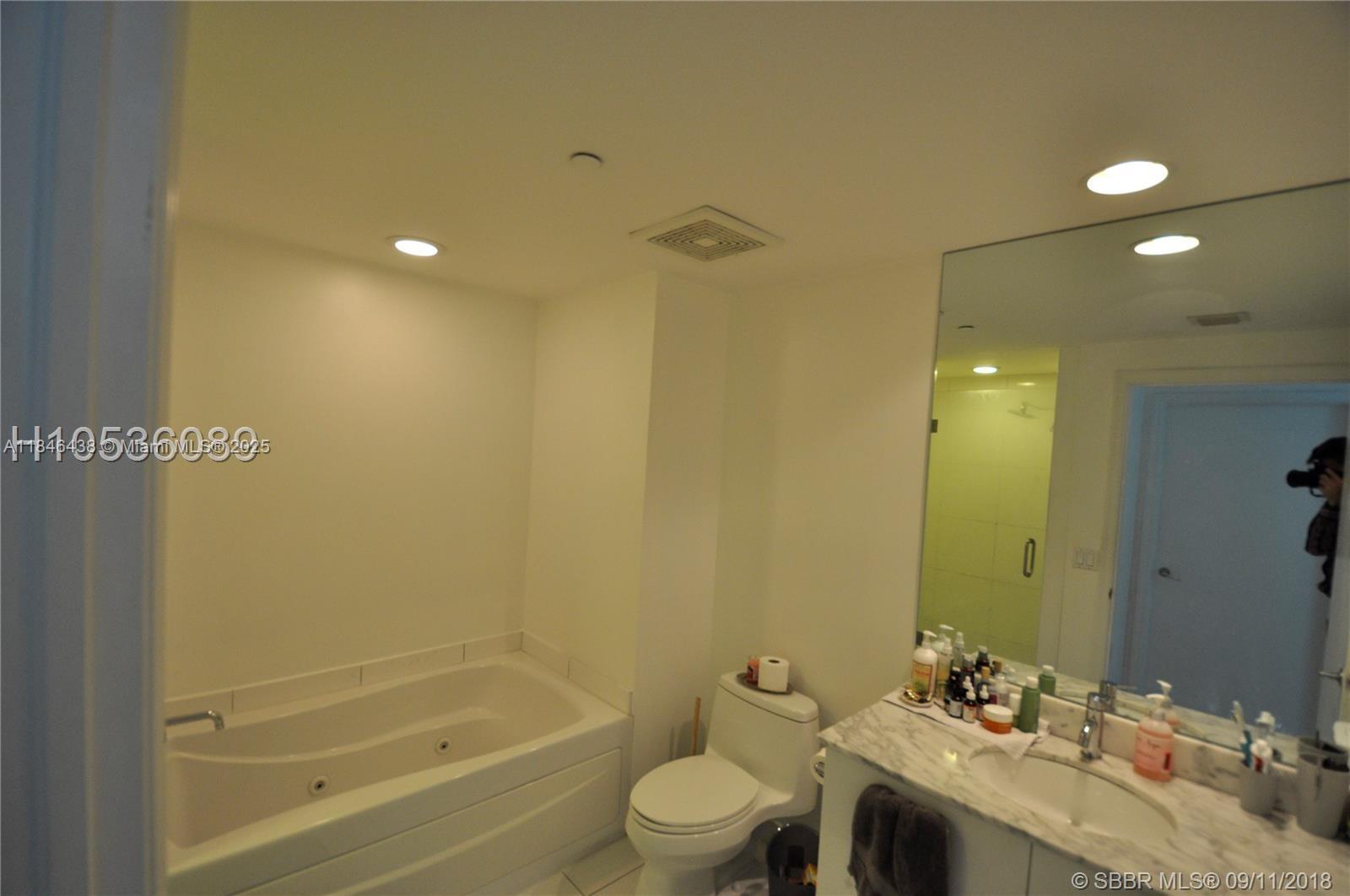 500 Brickell Avenue, Unit 2204 Miami, FL 33131 - Photo 16 of 19 a bathroom with a granite countertop sink a toilet and shower