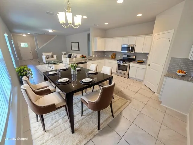 a view of a dining room with furniture and chandelier