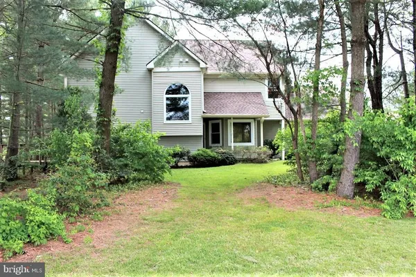 a front view of a house with a yard and trees