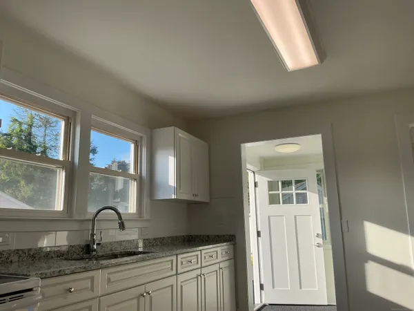 a kitchen with granite countertop a stove a sink and a window