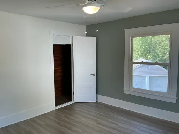 an empty room with wooden floor and windows