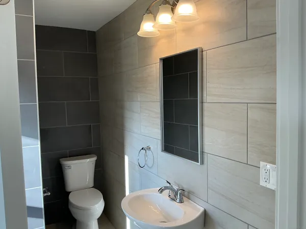 a bathroom with a toilet a sink and mirror