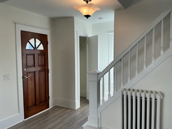 a view of an entryway with wooden floor and door