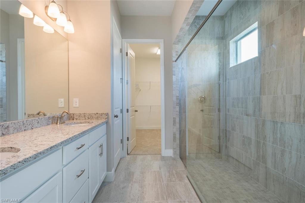 3331 Pilot Circle Naples, FL 34120 - Photo 14 of 28 a spacious bathroom with a granite countertop sink a mirror and a shower