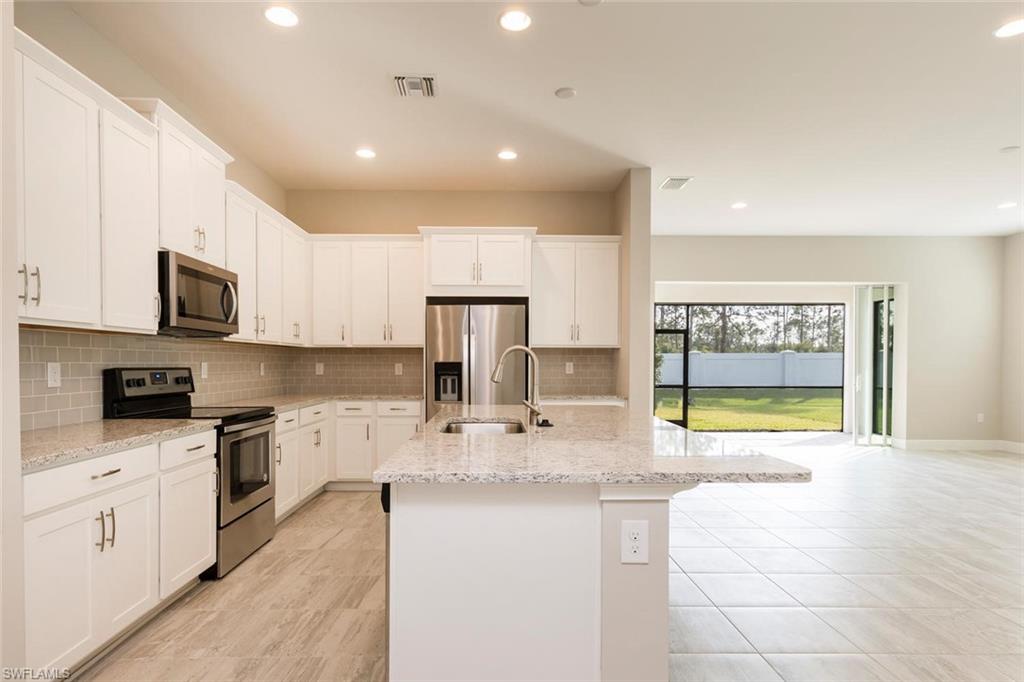 3331 Pilot Circle Naples, FL 34120 - Photo 7 of 28 a kitchen with stainless steel appliances granite countertop a stove and a sink