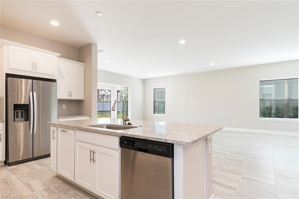 3331 Pilot Circle Naples, FL 34120 - Photo 10 of 28 a kitchen with granite countertop a sink stove and refrigerator