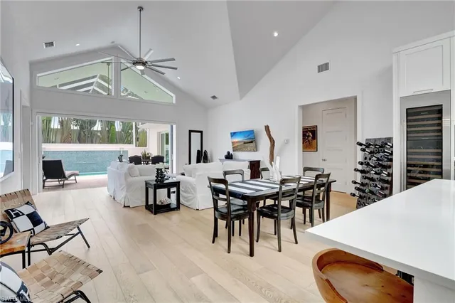 a dining room with wooden floor a chandelier a wooden table and chairs