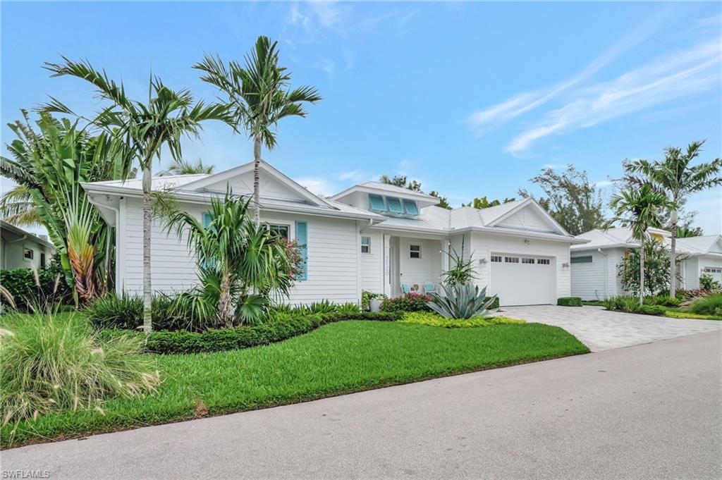 2120 Curtis Street Naples, FL 34112 - Photo 2 of 38 a front view of a house with a garden and palm trees