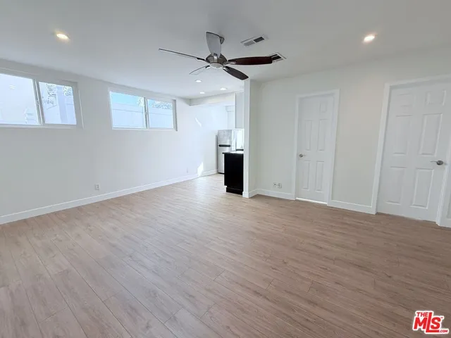 a view of a kitchen with wooden floor and a ceiling fan
