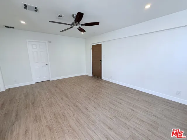 a view of a livingroom with a ceiling fan & wooden floor