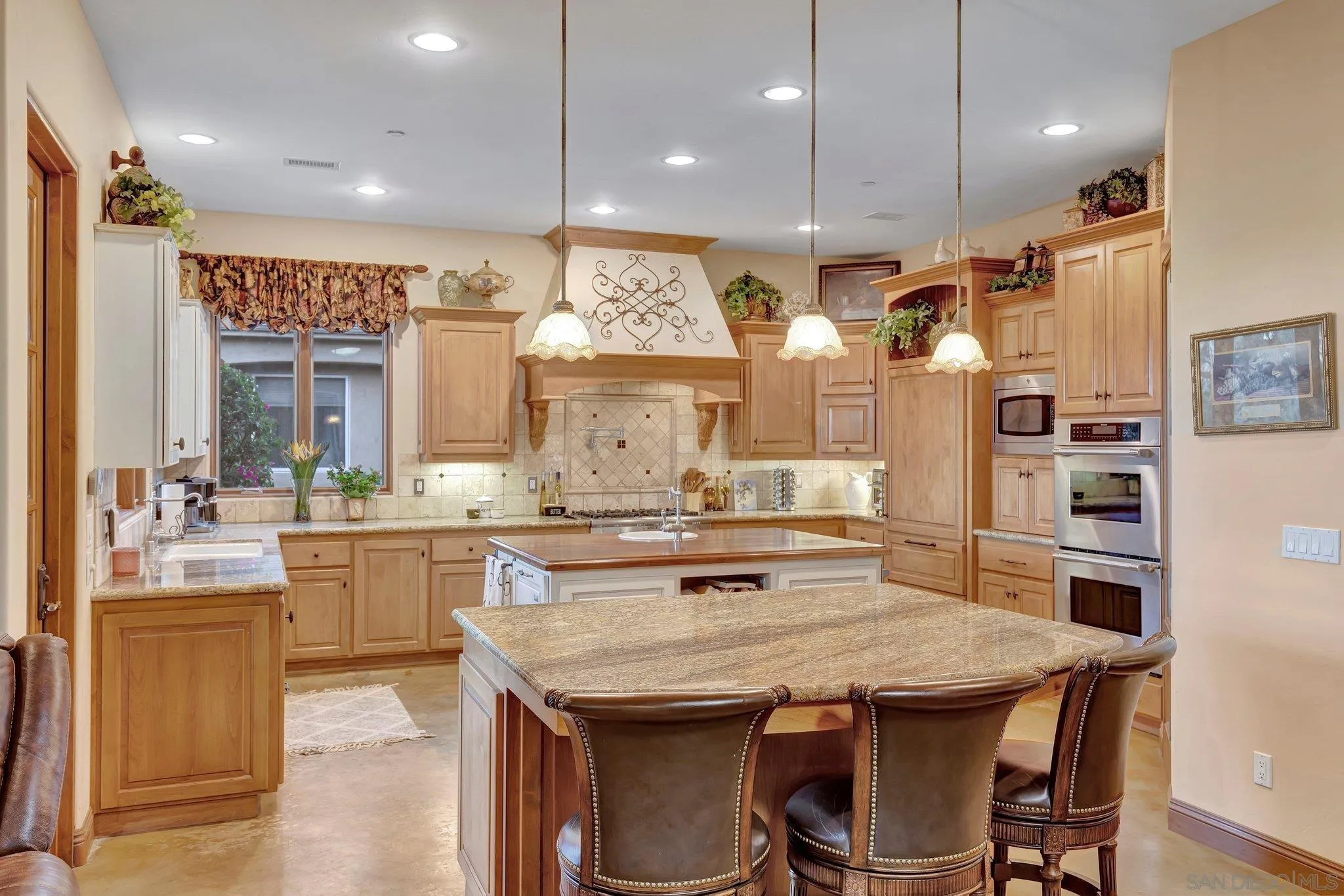 3401 Preakness Court Fallbrook, CA 92028 - Photo 22 of 52 a kitchen with granite countertop a table chairs stove and cabinets