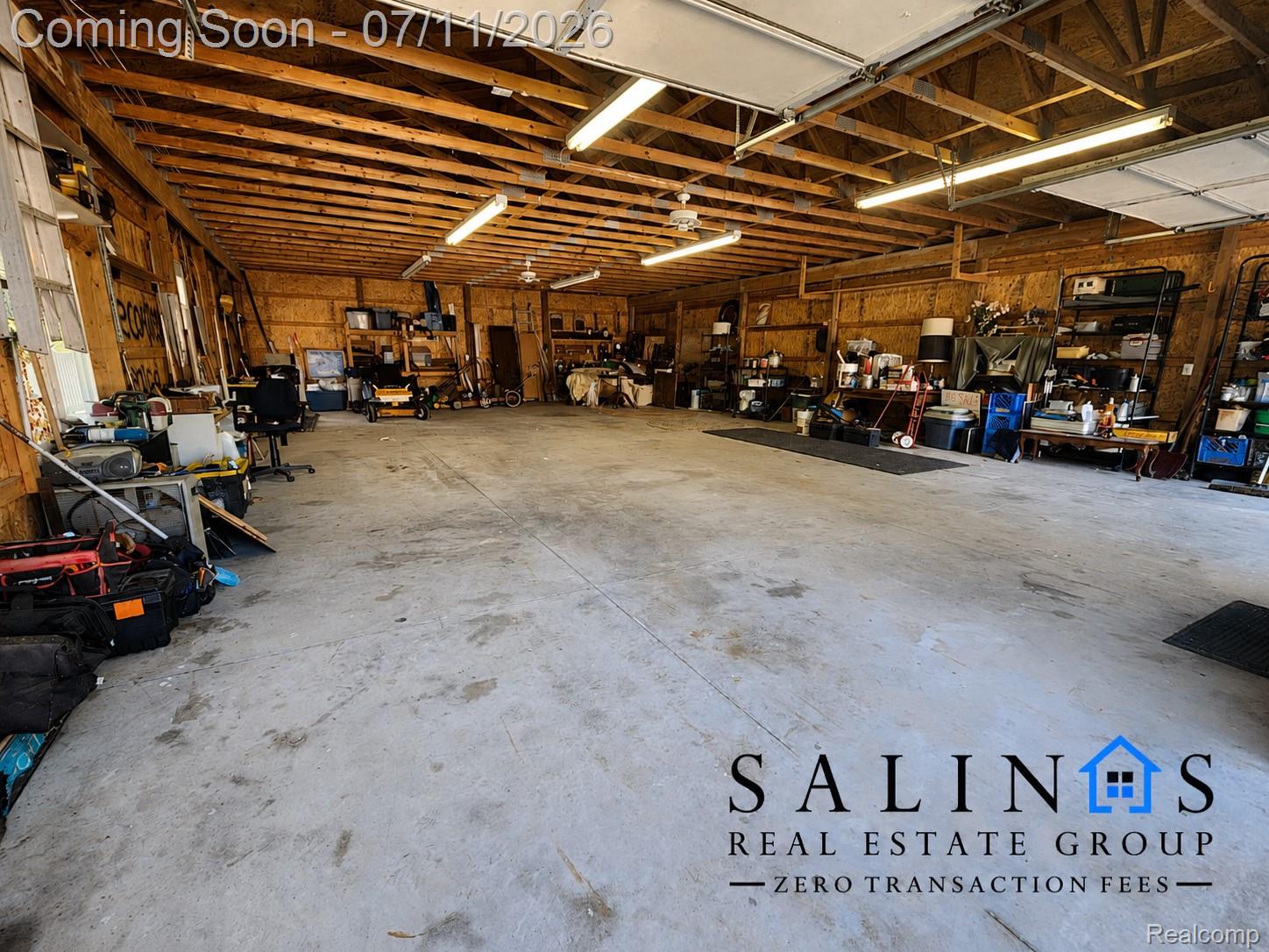 2120 Montague Road Davison, MI 48423 - Photo 37 of 37 Spacious Pole Barn featuring a concrete floor, exposed wood beam ceiling, multiple fluorescent light fixtures