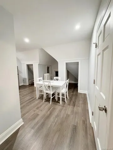 a dining room with furniture wooden floor a rug and a painting