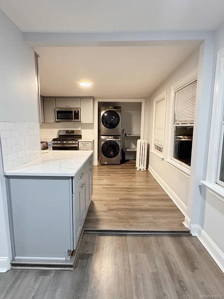 57 Pintard Avenue, Unit 3 New Rochelle, NY 10801 - Photo 14 of 23 a kitchen with stainless steel appliances a stove a sink and white cabinets