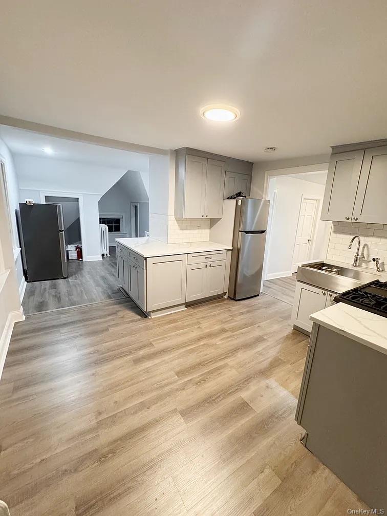 57 Pintard Avenue, Unit 3 New Rochelle, NY 10801 - Photo 17 of 23 a large white kitchen with cabinets and wooden floor