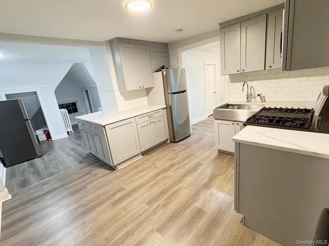 a kitchen with granite countertop a stove a sink and a refrigerator