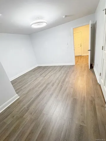 an empty room with wooden floor and a window