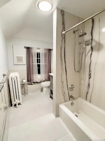 a bathroom with a tub a sink and a large mirror