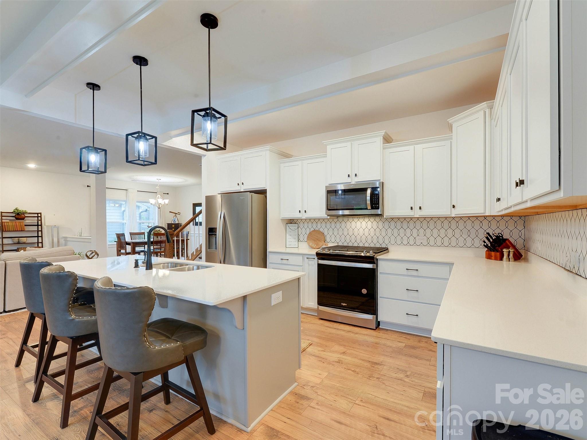 1928 Thoreau Way York, SC 29745 - Photo 8 of 43 a kitchen with stainless steel appliances kitchen island granite countertop a refrigerator a stove top oven a sink a dining table and chairs with wooden floor