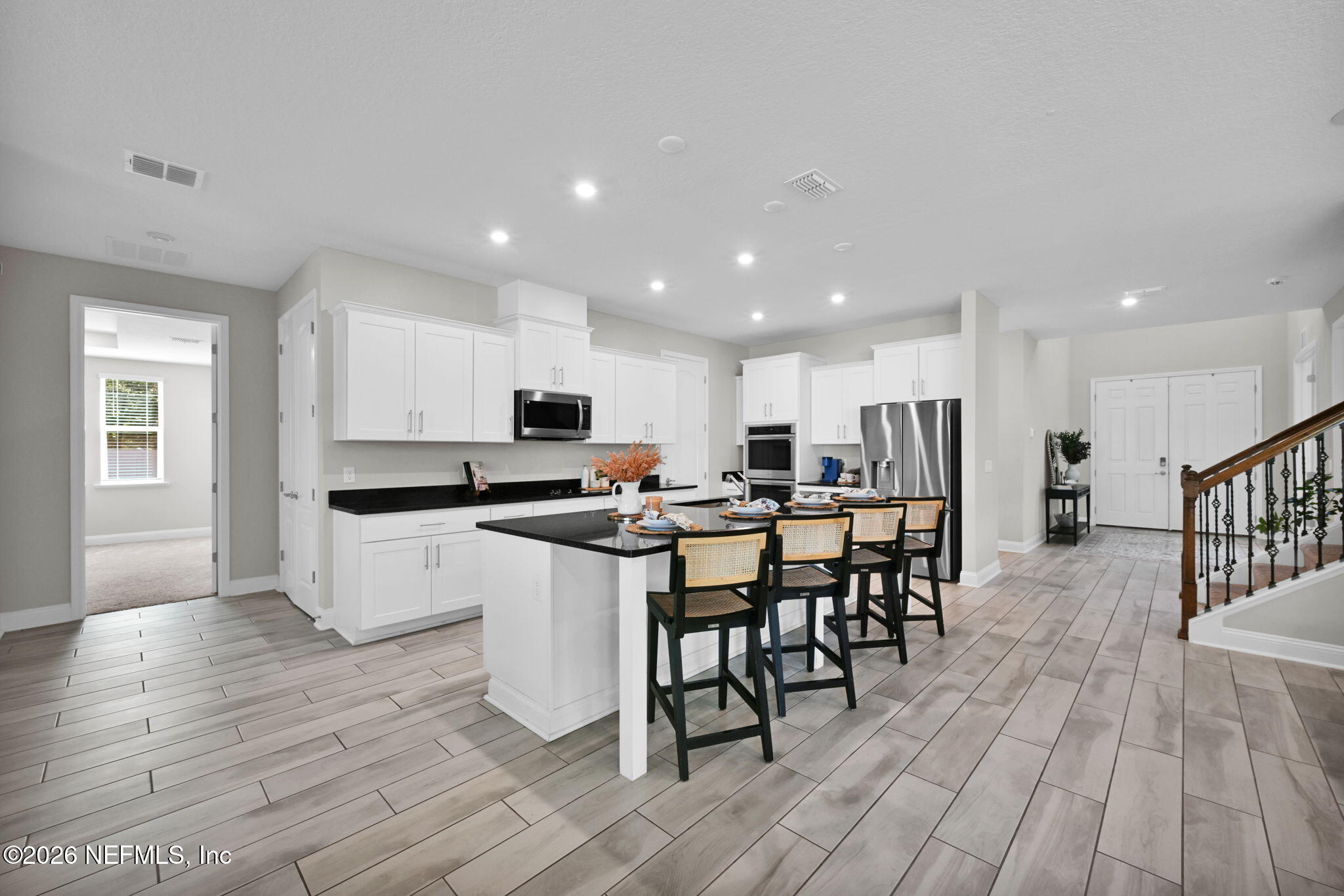 4050 Coyote Court Middleburg, FL 32068 - Photo 19 of 93 a kitchen with a dining table chairs wooden floor stainless steel appliances and cabinets