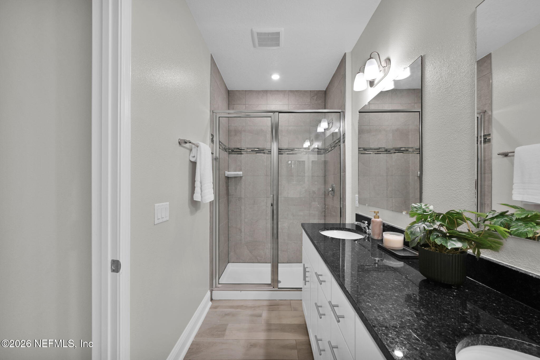 4050 Coyote Court Middleburg, FL 32068 - Photo 49 of 93 a spacious bathroom with a granite countertop shower a mirror and a sink