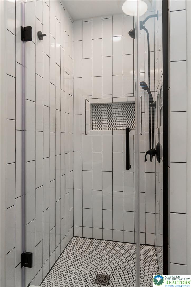540 Briar Road Pen Argyl, PA 18072 - Photo 33 of 66 A sleek shower enclosure features floor-to-ceiling subway tile and a practical built-in niche for toiletries.