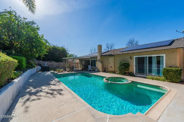 a view of a house with a swimming pool and a yard